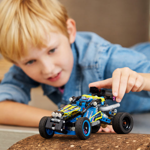 Boy playing with LEGO Technic Off Road Buggy